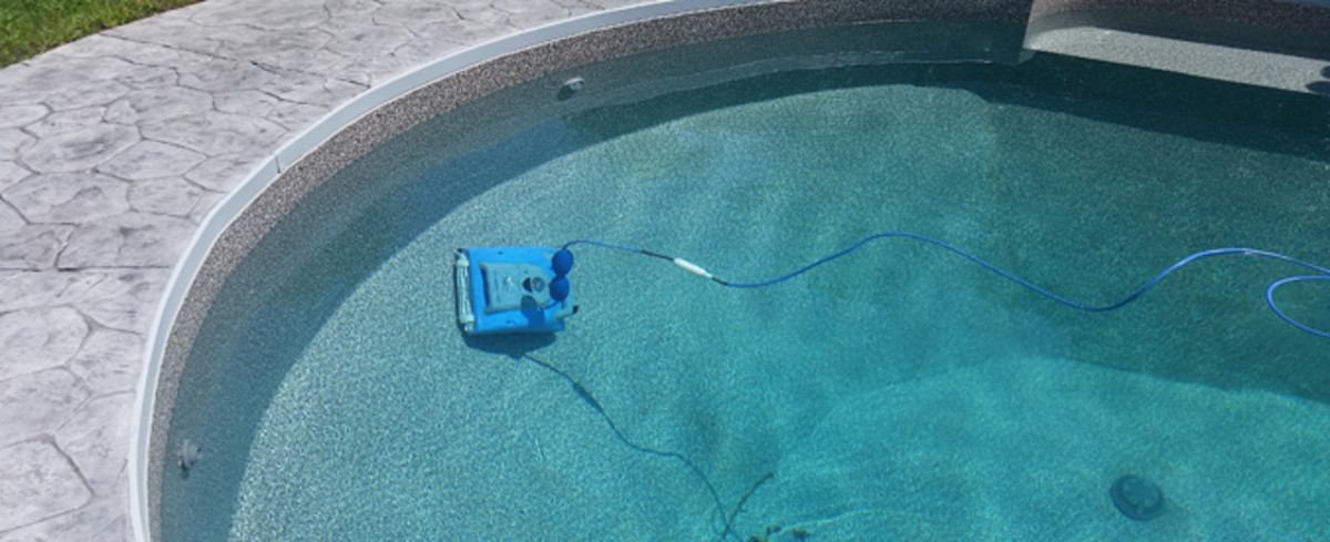 A robot pool cleaner cleaning the side of a pool.