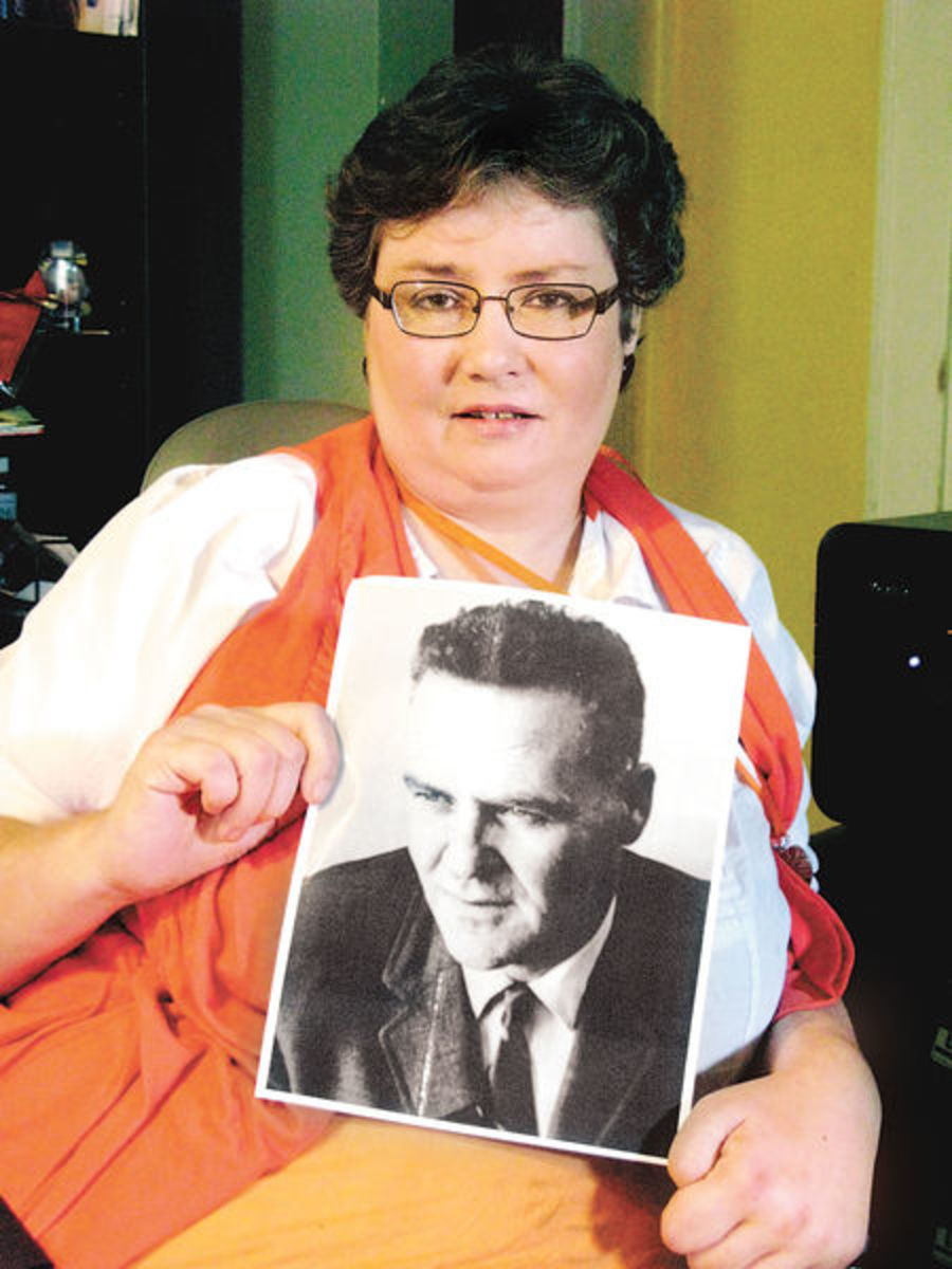 Taunia Bowman holding a picture of her father, Woodrow Derenberger.