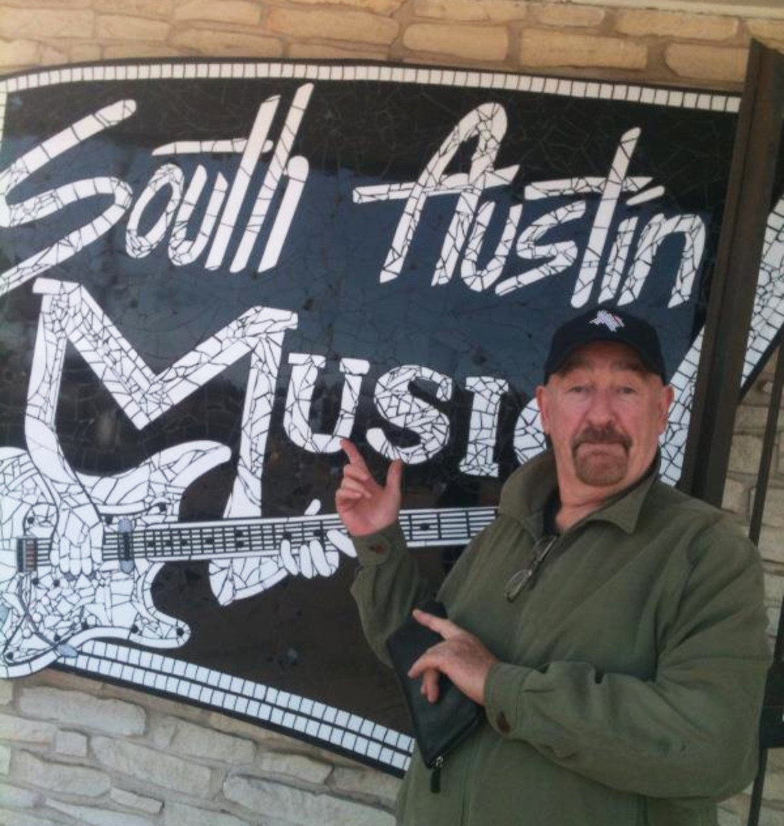 Dave Mason in front of South Austin Music outdoor sign on Wedi board