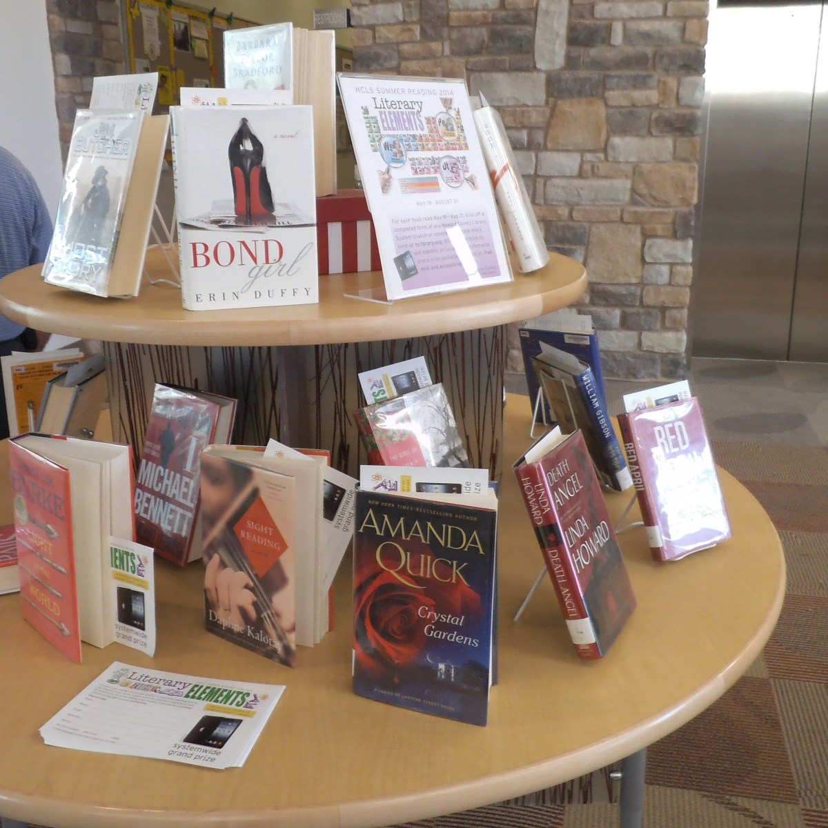 You can stand the book up by fanning out the pages or get some slim wire racks to place the books upright on the tabletop display. 