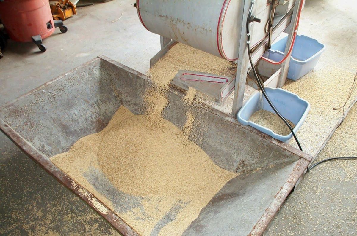 The grain spills from one screen to another (each with different sized holes), until it falls at the last into a hopper or other container, and is finished.