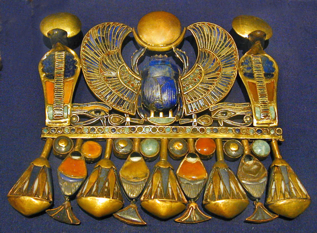 Another more elaborate pectoral of King Tut: the winged scarab sitting on the "neb" basket and holding the "Ra" sub disk is surrounded by symbols of the sun and resurrection.