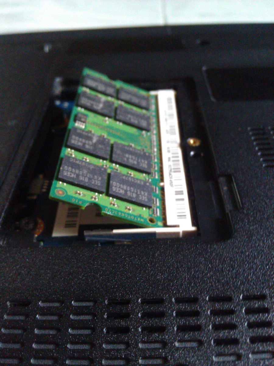 The old RAM card unlatched and resting in the slot.