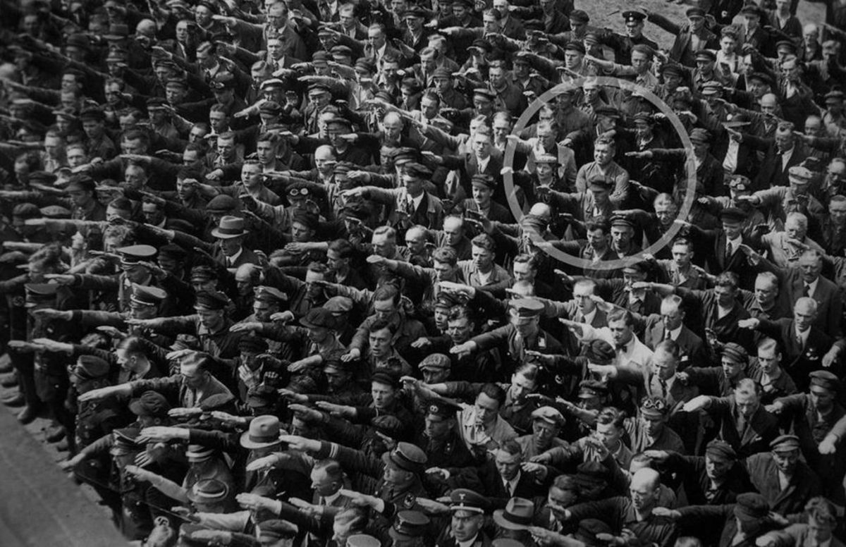 Shipyard worker Landmesser stands with arms folded.
