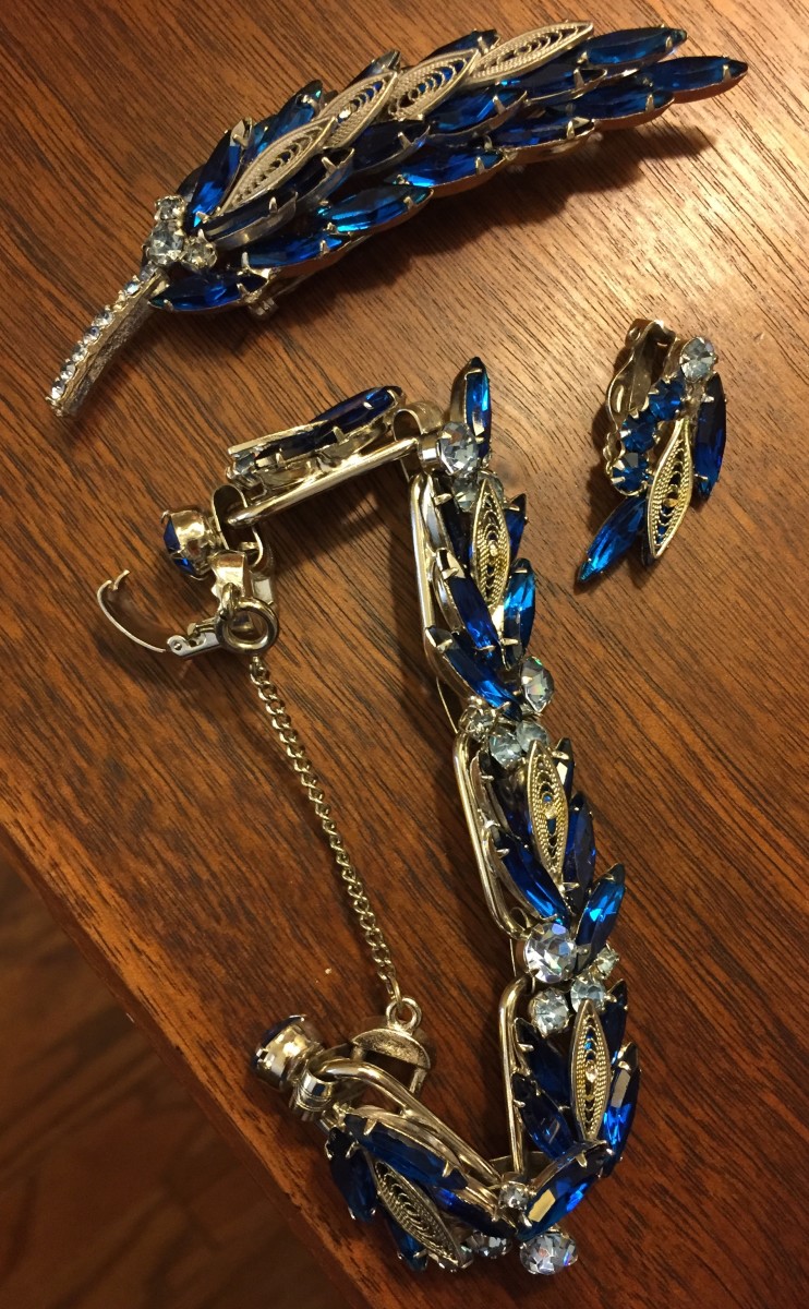 Bracelet, brooch, and one surviving earring, believed to be "Juliana" by DeLizza & Elster, 1960s. Appears to be missing a few tiny stones in the center of some of the silver leaves.