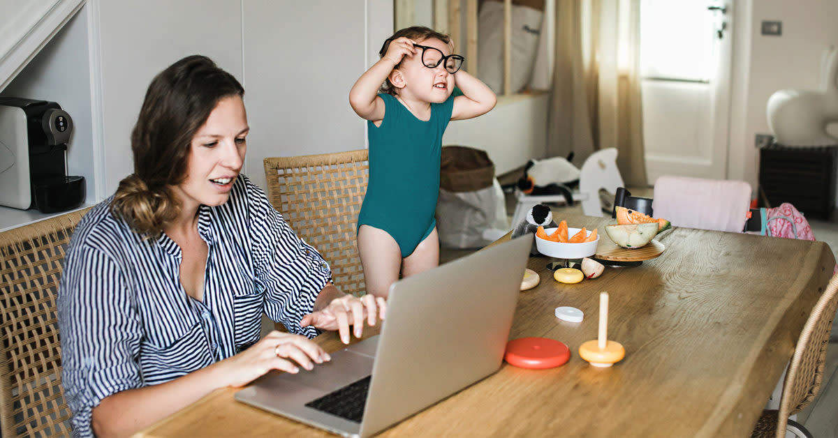 A mother working from home with her daughter on the side.