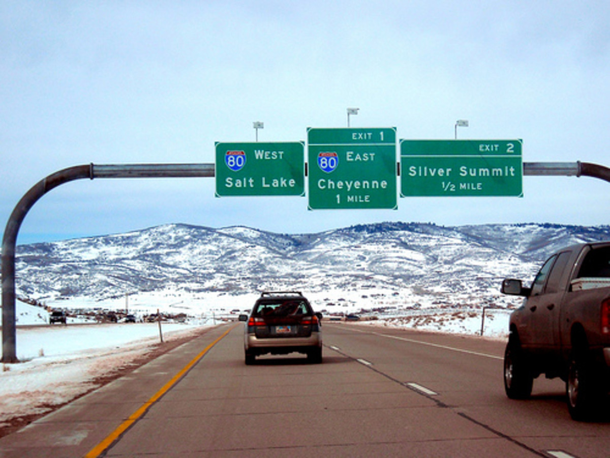 How are distances listed on freeway signs between cities determined?