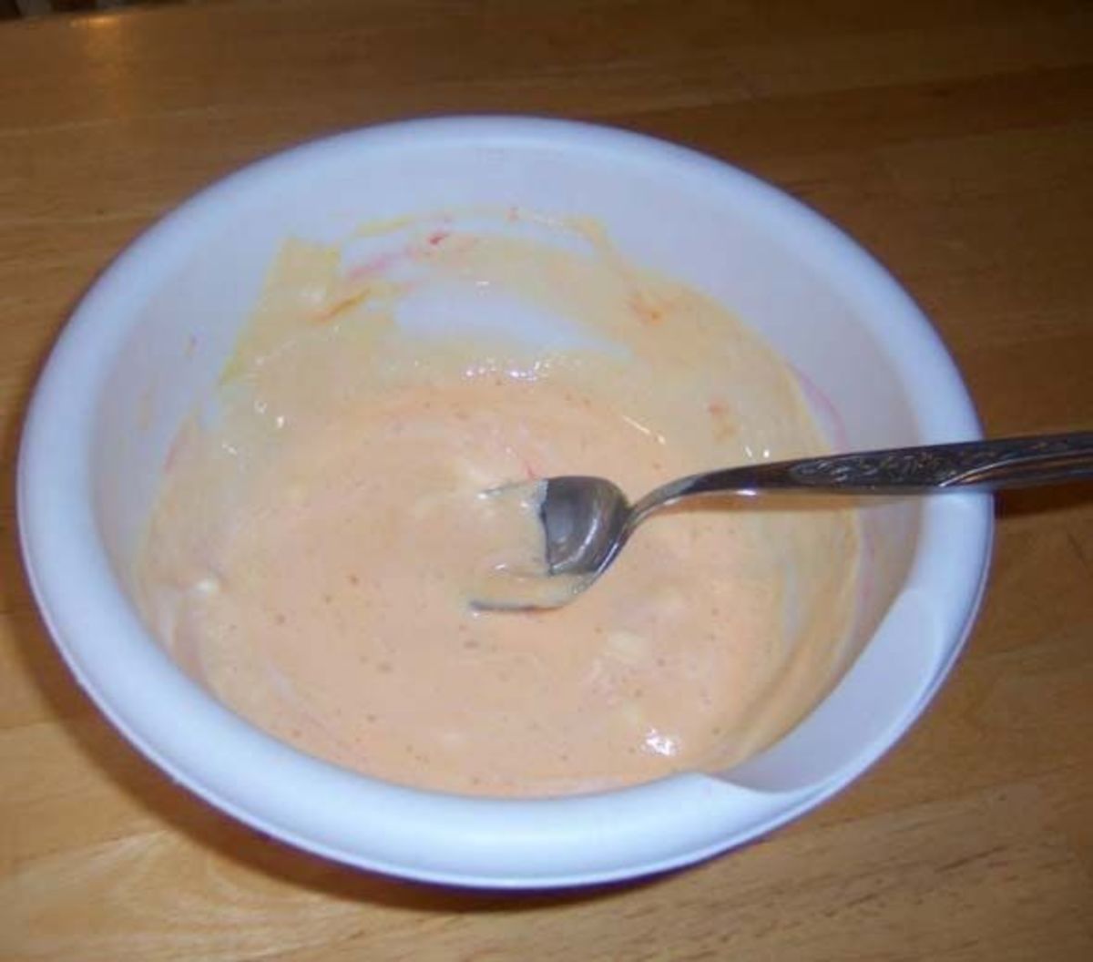 A gooey bowl of melted marshmallows, food dye, water, and cooking oil stirred to a uniform color and consistency