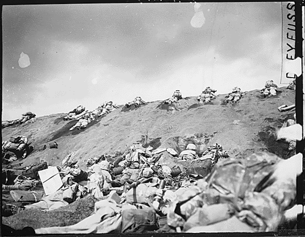 Marines of the 5th Division inch their way up a slope on Red Beach No. 1 toward Surbachi Yama as the smoke of the battle drifts about them. Iwo Jima, February 19, 1945.