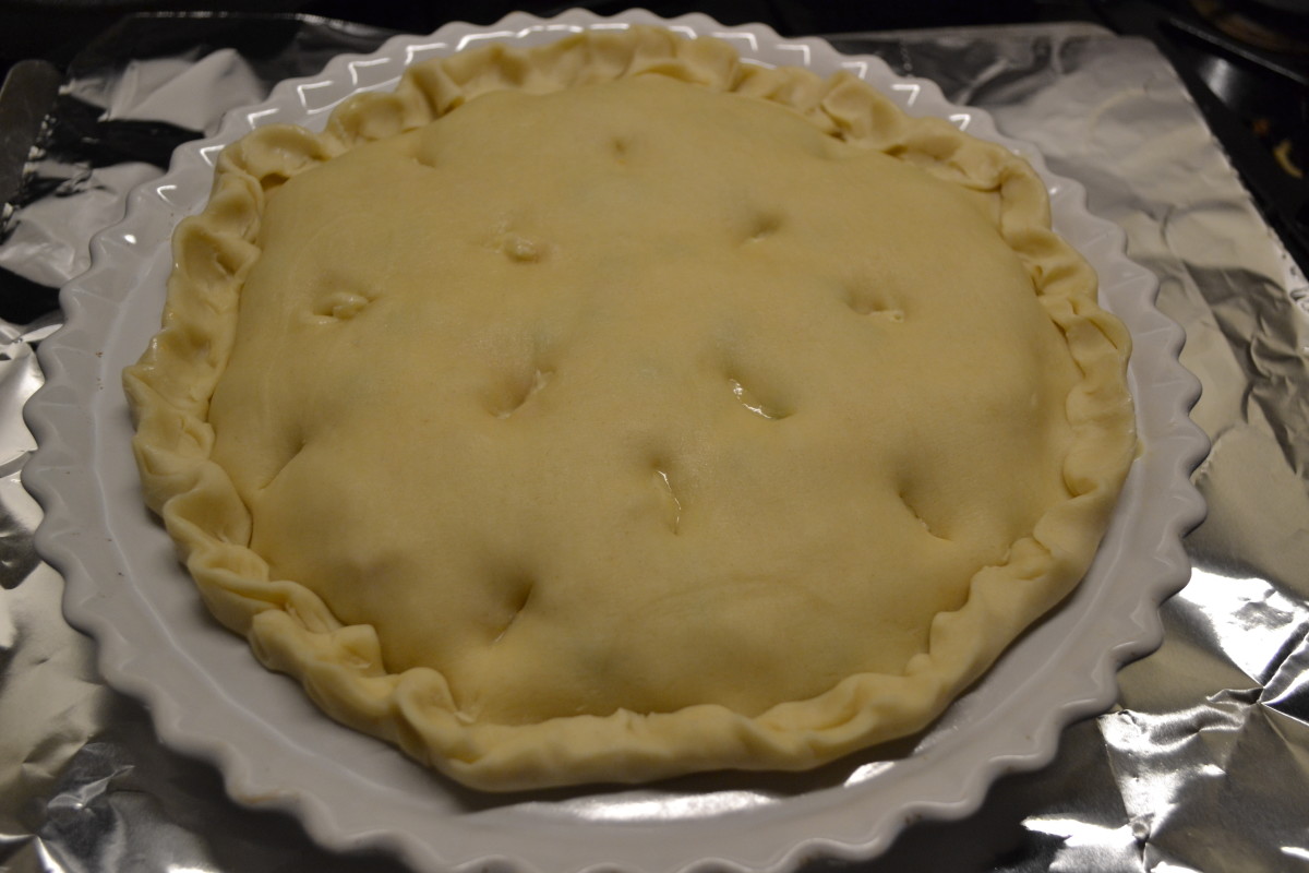 Once filled, top your pot pie with the second crust, fold under and crimp the edges, and cut a few steam holes. Brush top crust with melted butter, if desired.