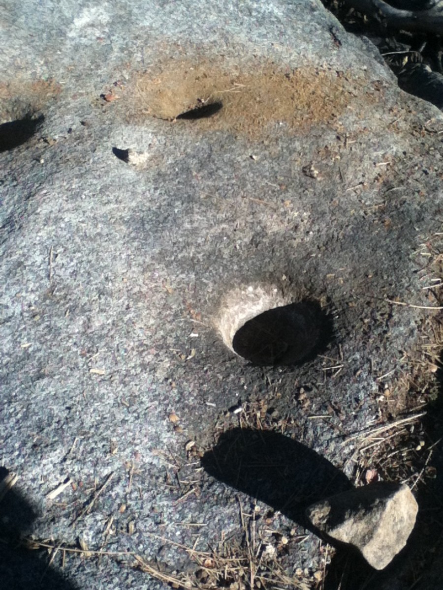 Shadows inside the holes of the metate rocks.  The metatee rocks is where Serrano Indians used to grind acorns into meal to make flat breads and mushes.