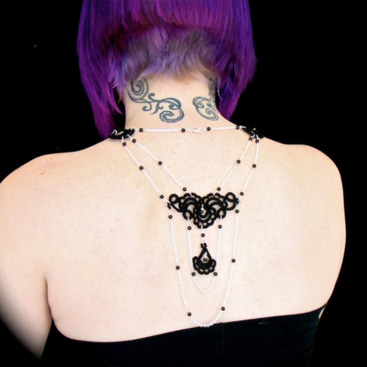 Necklace consists of black cotton thread for the tatting, plus silver plated chain and Swarovski crystals.