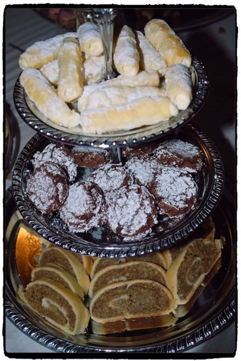 Three tiered cookie table display featuring lady fingers, earthquake cookies, and kolachi.  