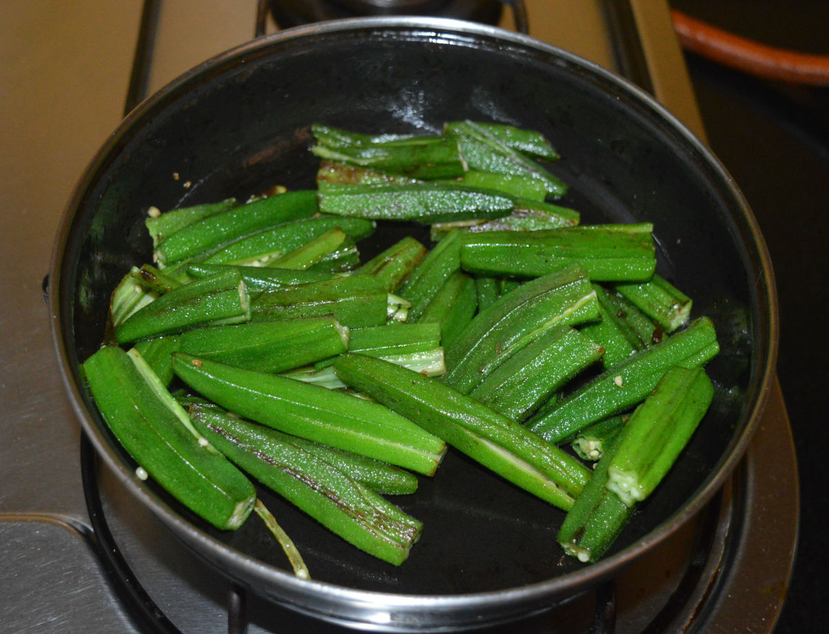 Heat a tablespoon oil in a deep-bottomed pan. Add okra. Saute until they are halfway cooked. 