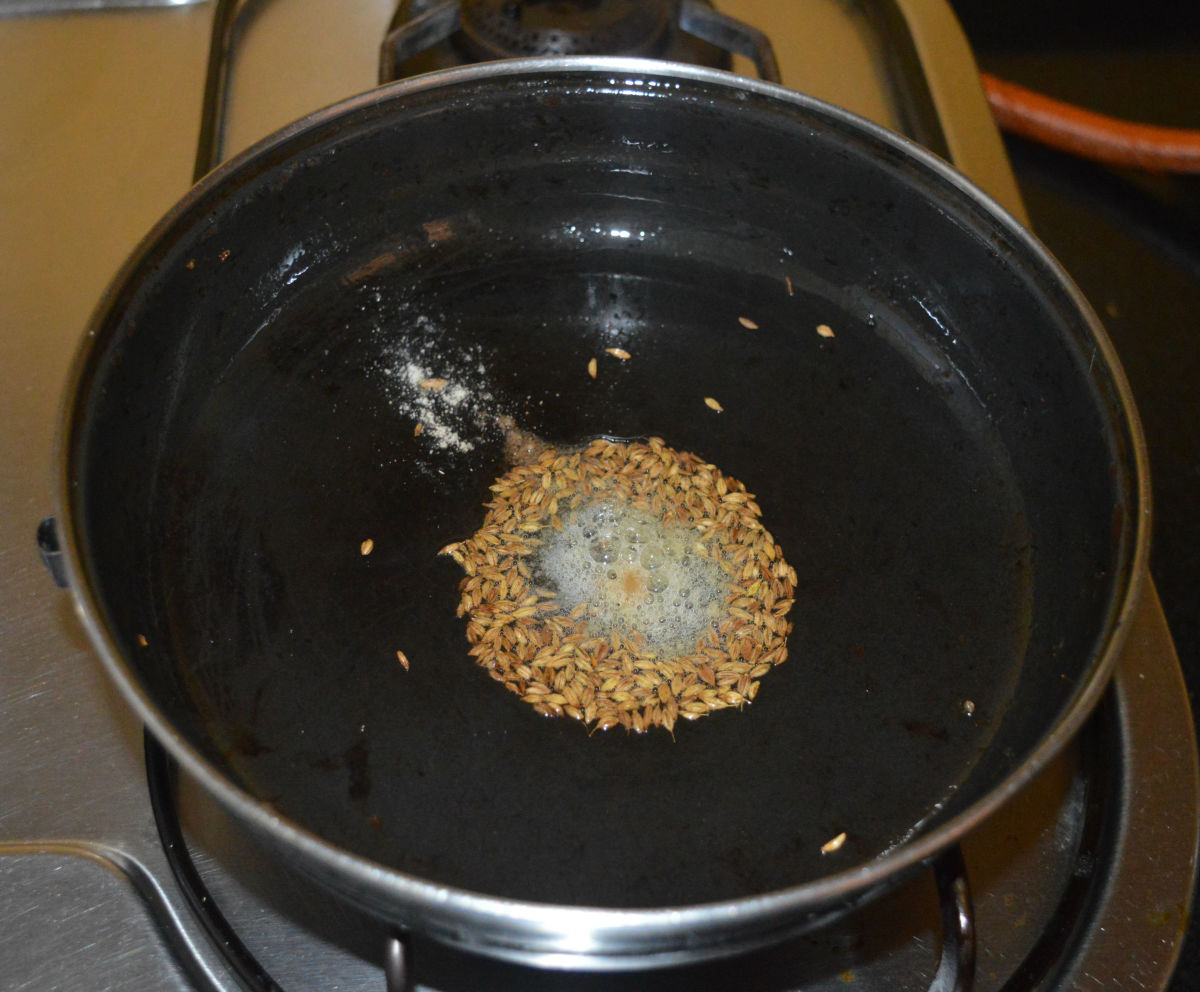Step two: In the same pan, add the remaining oil. Heat it. Throw in cumin seeds. Allow it to crackle. Add hing powder. Saute for 3-4 seconds.