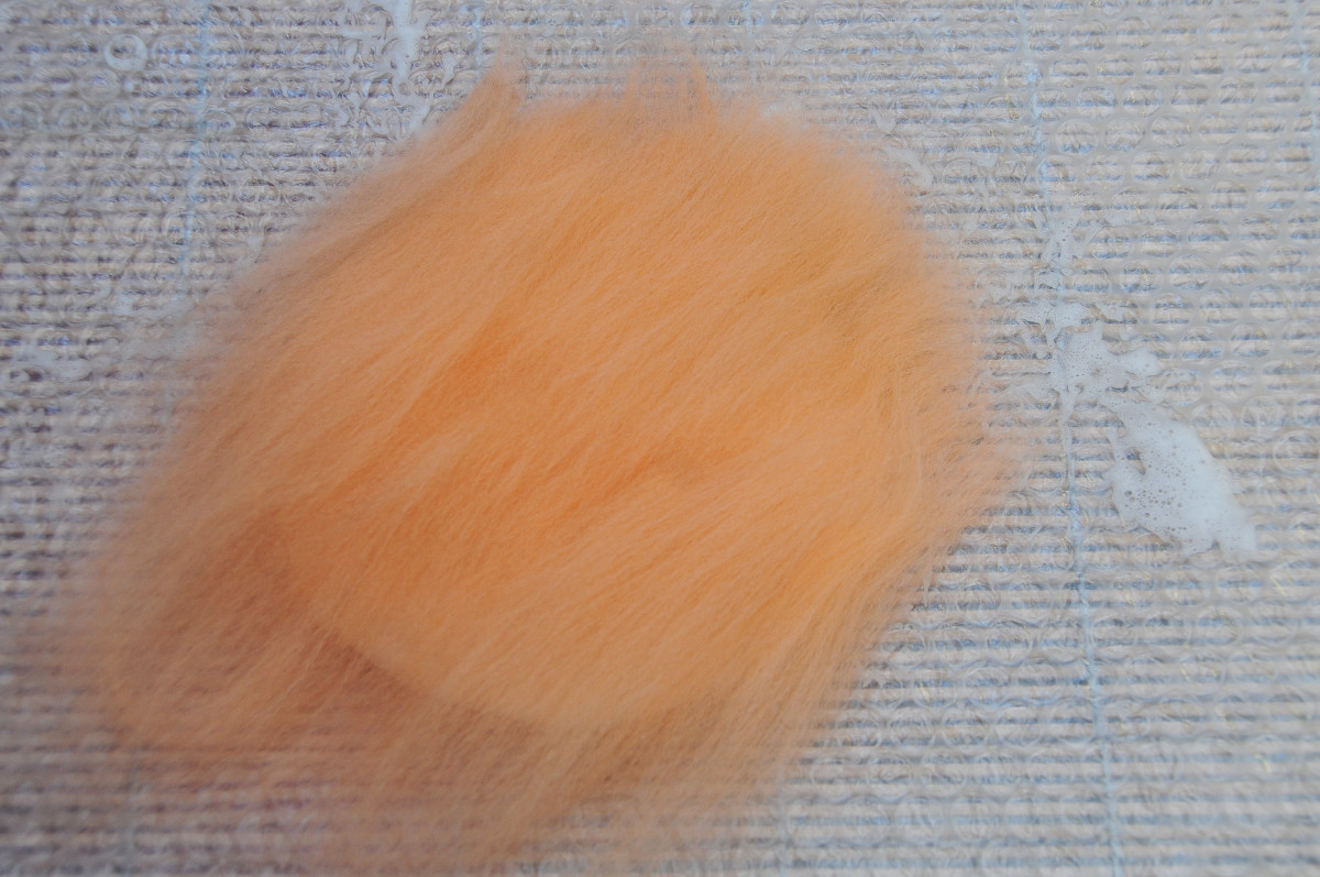 Cover the white layer with a thin layer of orange fibers.