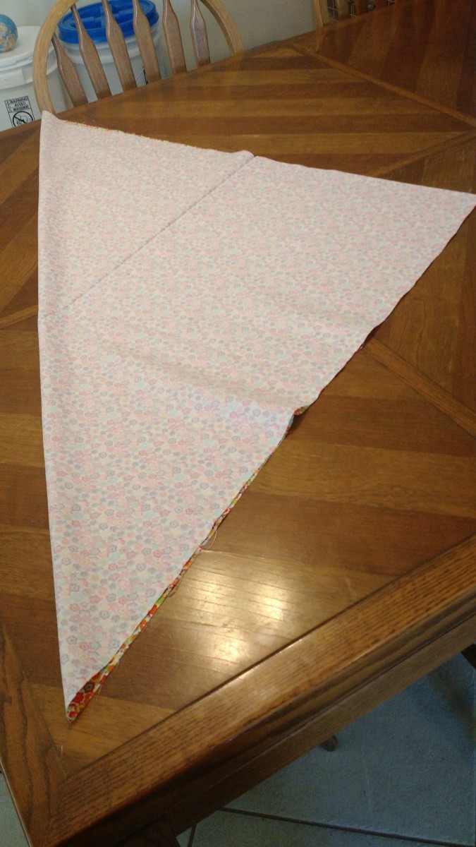 Turn the fabric inside out so that the pattern is on the inside of the triangle.