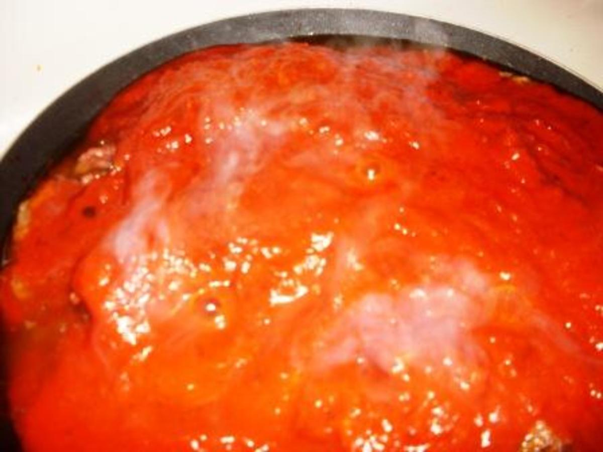 Delicious ground beef simmering in savory tomato sauce in preparation to be added to a scrumptious homemade beef lasagna.