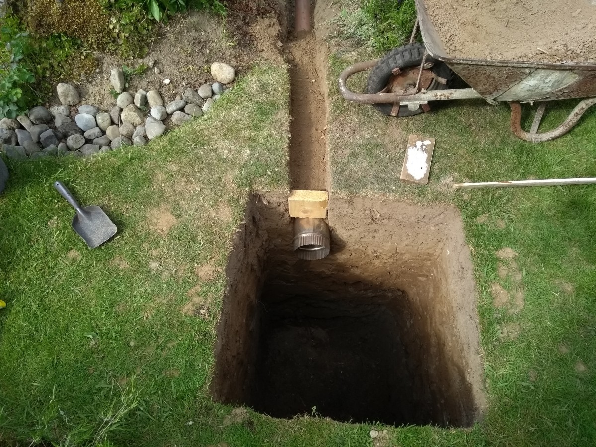I recycled a waste piece of stainless steel flue to reach the end of the trench because I didn't have enough waste pipe.