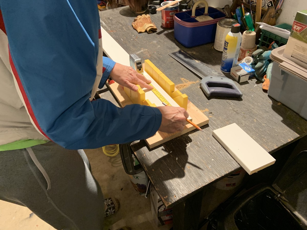 Cutting the boards to length using a cheap miter box and saw. I clamped the miter box to my work bench to keep it from slipping while we cut the boards.