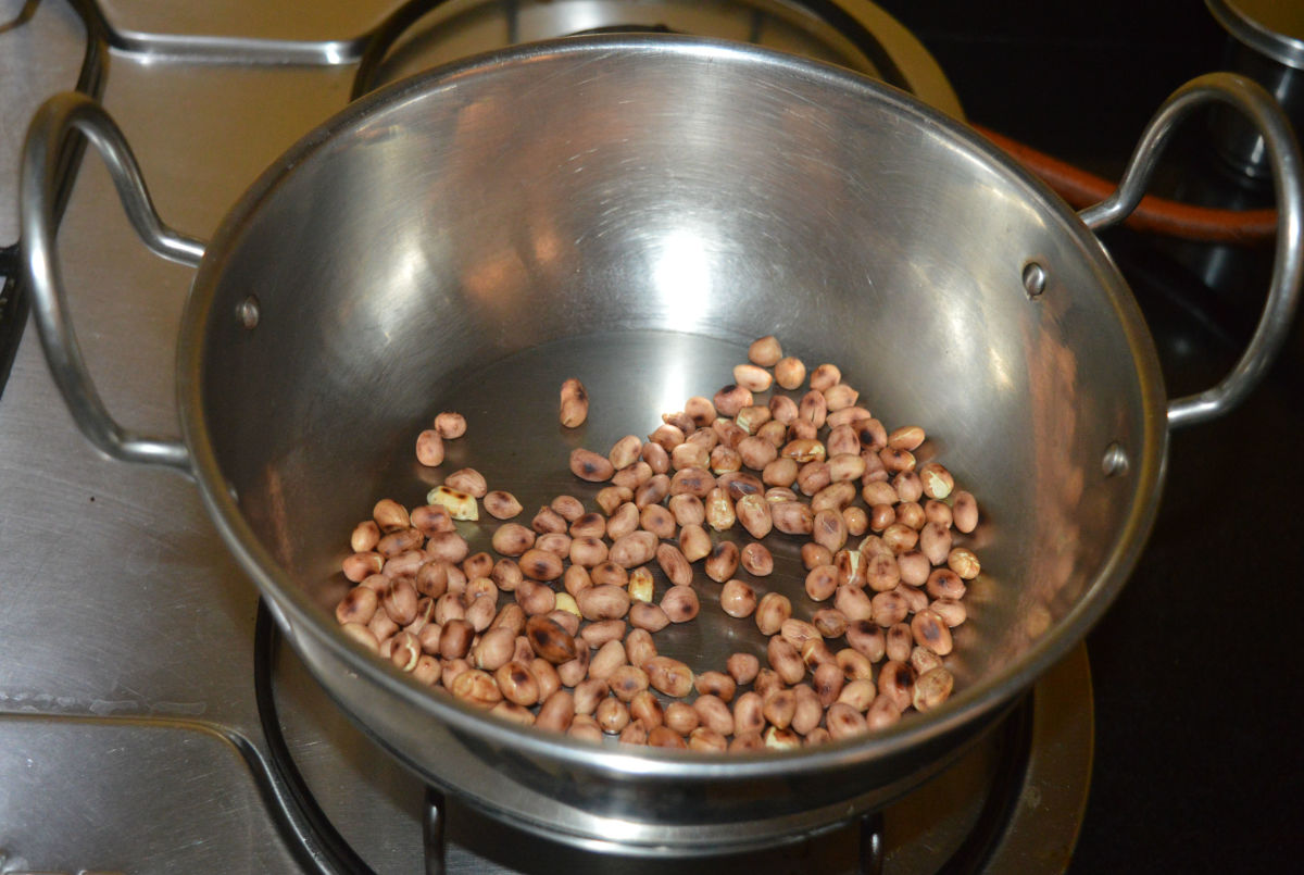 Step one: Heat a deep-bottomed pan and add peanuts. Saute on medium heat until they get brownish spots on the skin. Turn off the heat and transfer the fried peanuts to a plate. Allow it to cool.