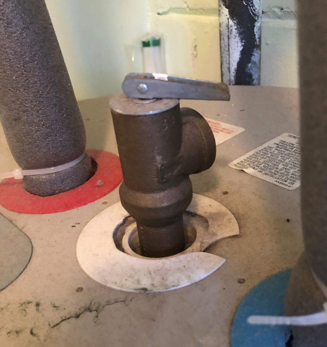 A pressure relief valve opens before tank pressure reaches a dangerous level. The installer failed to connect a drain pipe.
