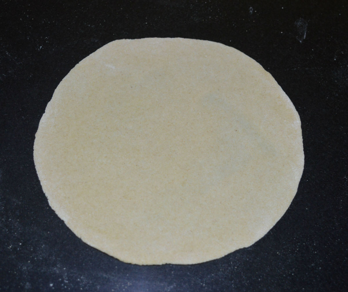 Step four: Roll out each ball of dough to form a disc of 6 or 7 inches in diameter. Divide the stuffing into four portions.