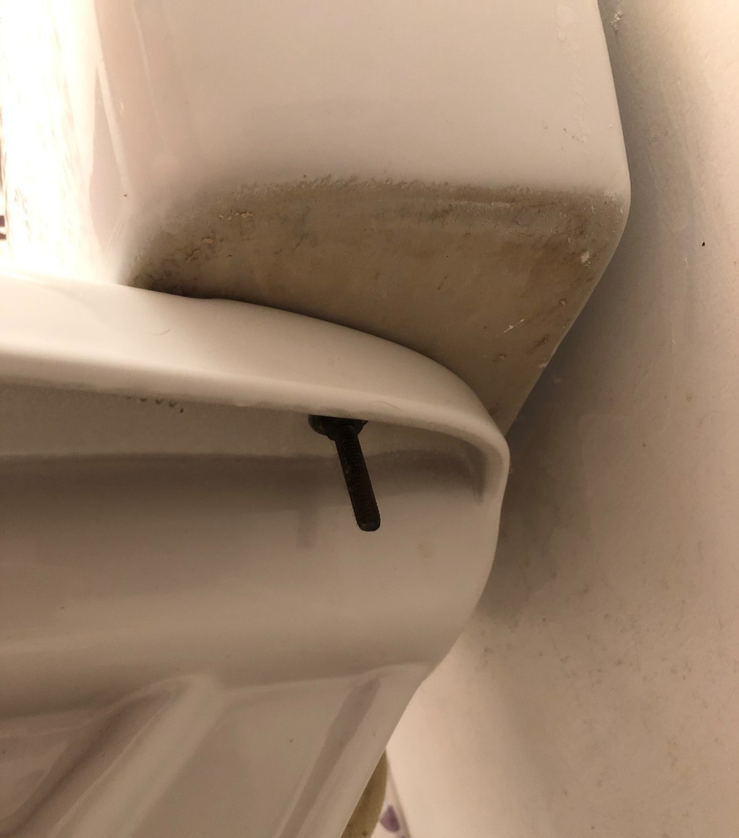 Water leaking between the tank and bowl indicates worn gaskets or seals. Because of the age of the other parts inside, this toilet received a complete rebuild kit, which included new gaskets and seals.