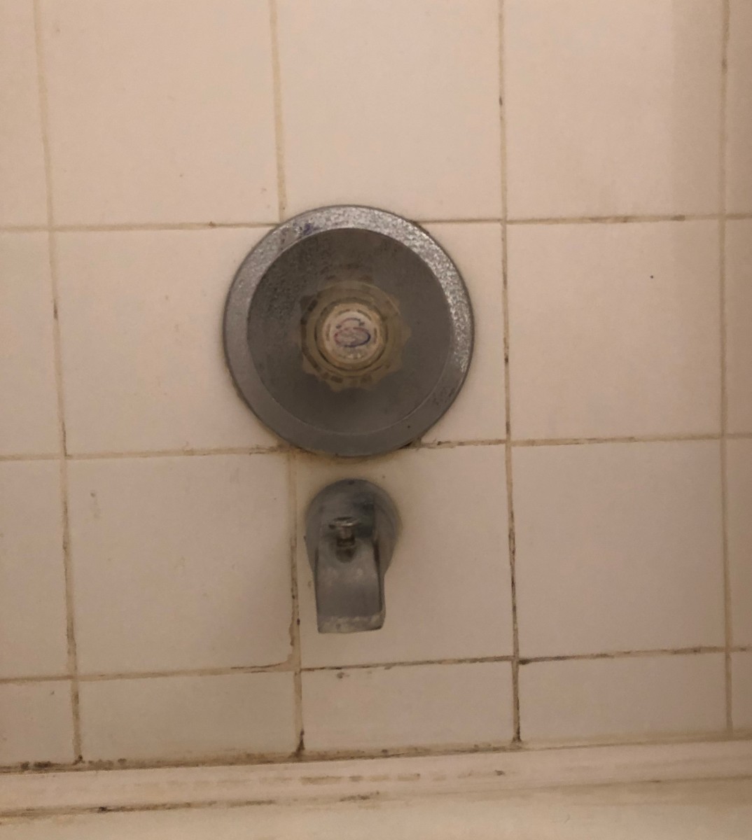 Replacing this worn shower valve with a modern model helps complete the bathroom remodeling project.