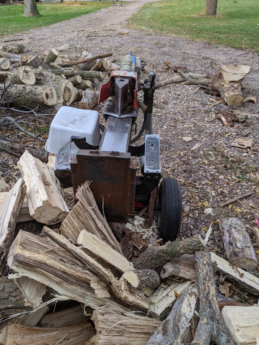 Wood splitter. Gasoline powered, with a cylinder that moves a sharp edge back and forth for splitting each chunk.