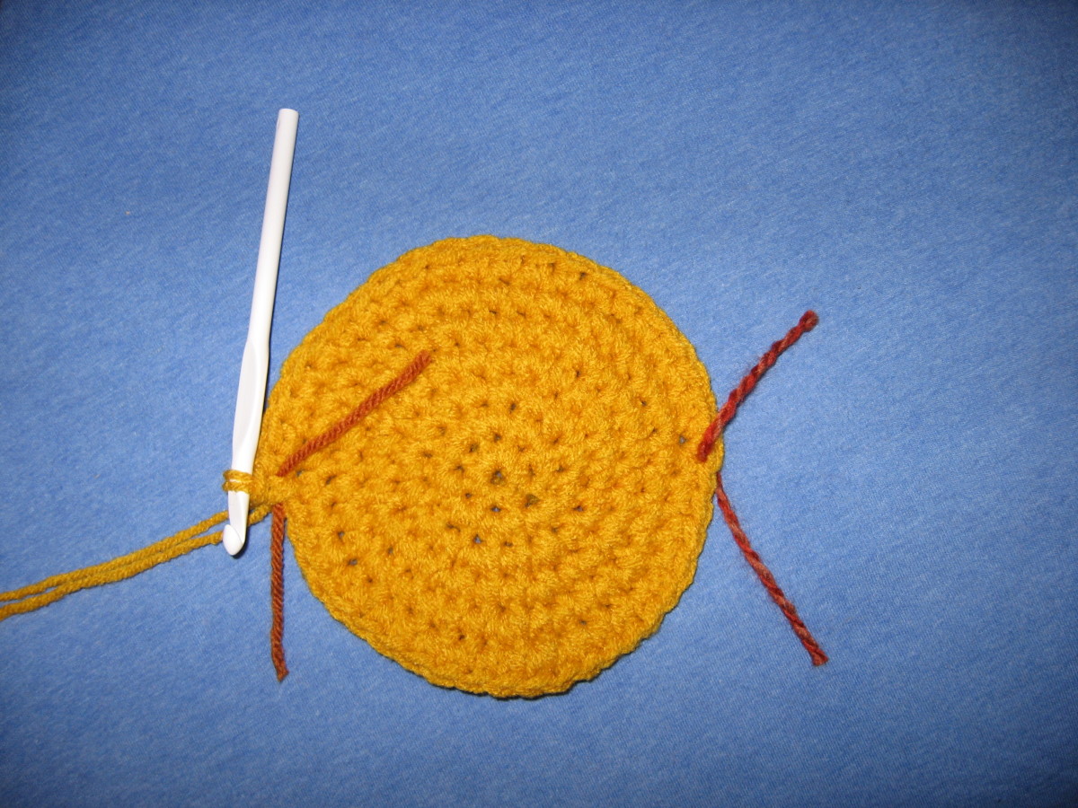 This shows the yellow part of the hat being worked in a spiral.  As you can see, there is a stitch marker at the row beginning (North) and directoly opposite the row beginning (South)