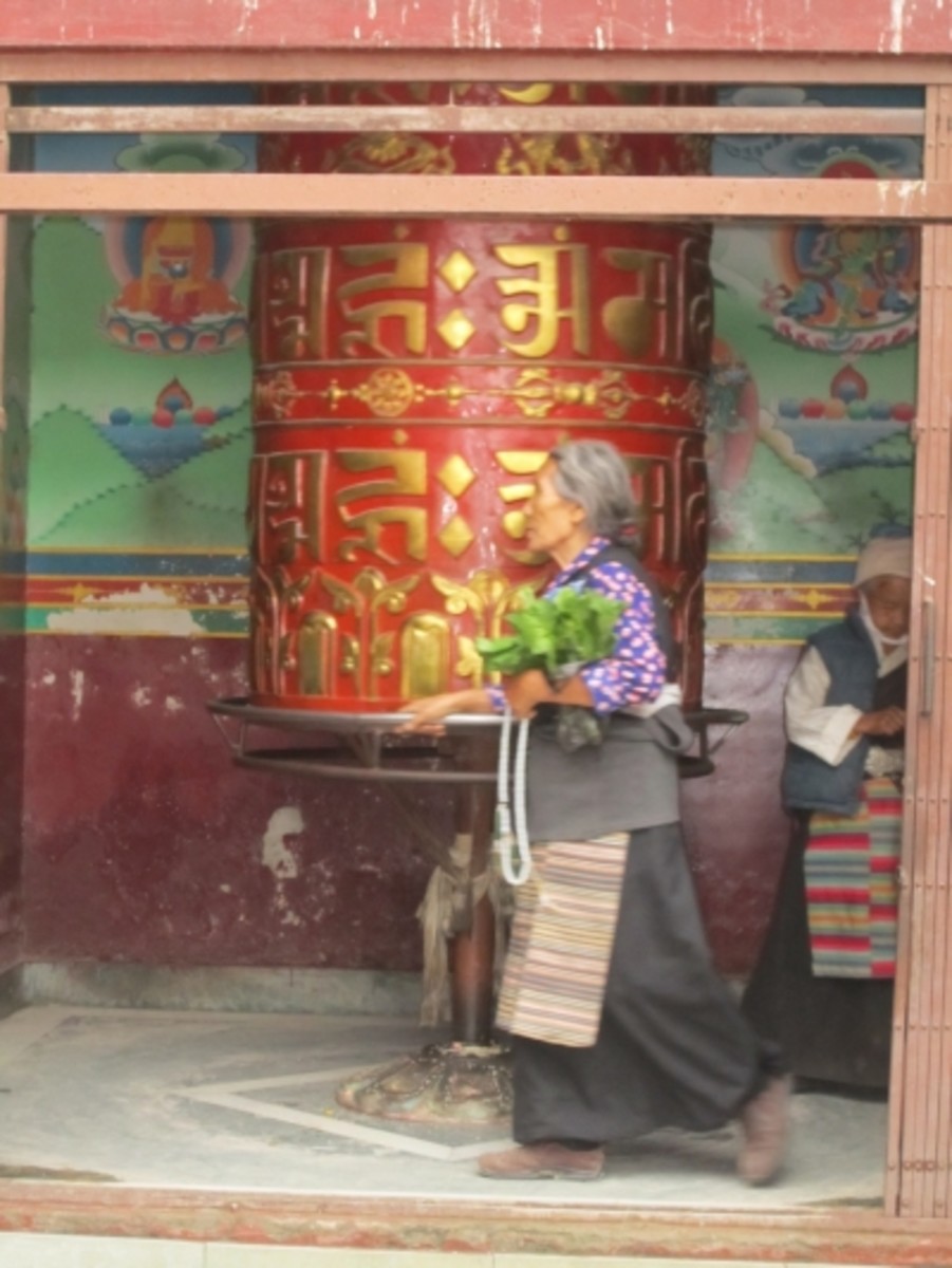 A large prayer wheel in an alcove near the stupa