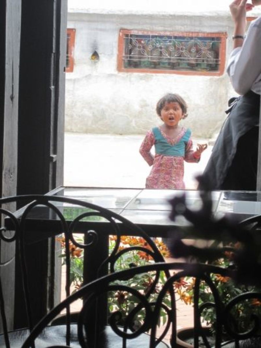 A little girl stops by for some bread while a waitress watches.