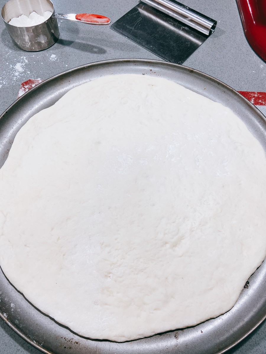 Transfer the dough on a pizza baking pan.