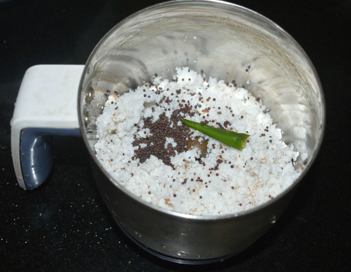 Step two: In a mixing jar, add grated coconut, mustard seeds, and green chili. Grind to get a smooth paste. Add water while grinding if needed.