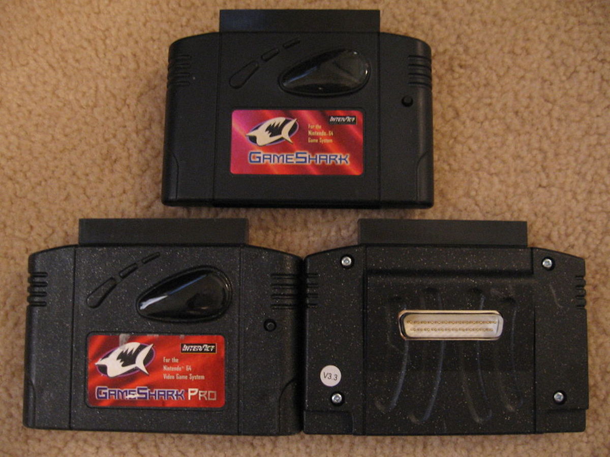 Three different versions of the GameShark for N64, with the GameShark 3.3 version having a connect port for computers to edit cheats and allegedly dump roms.