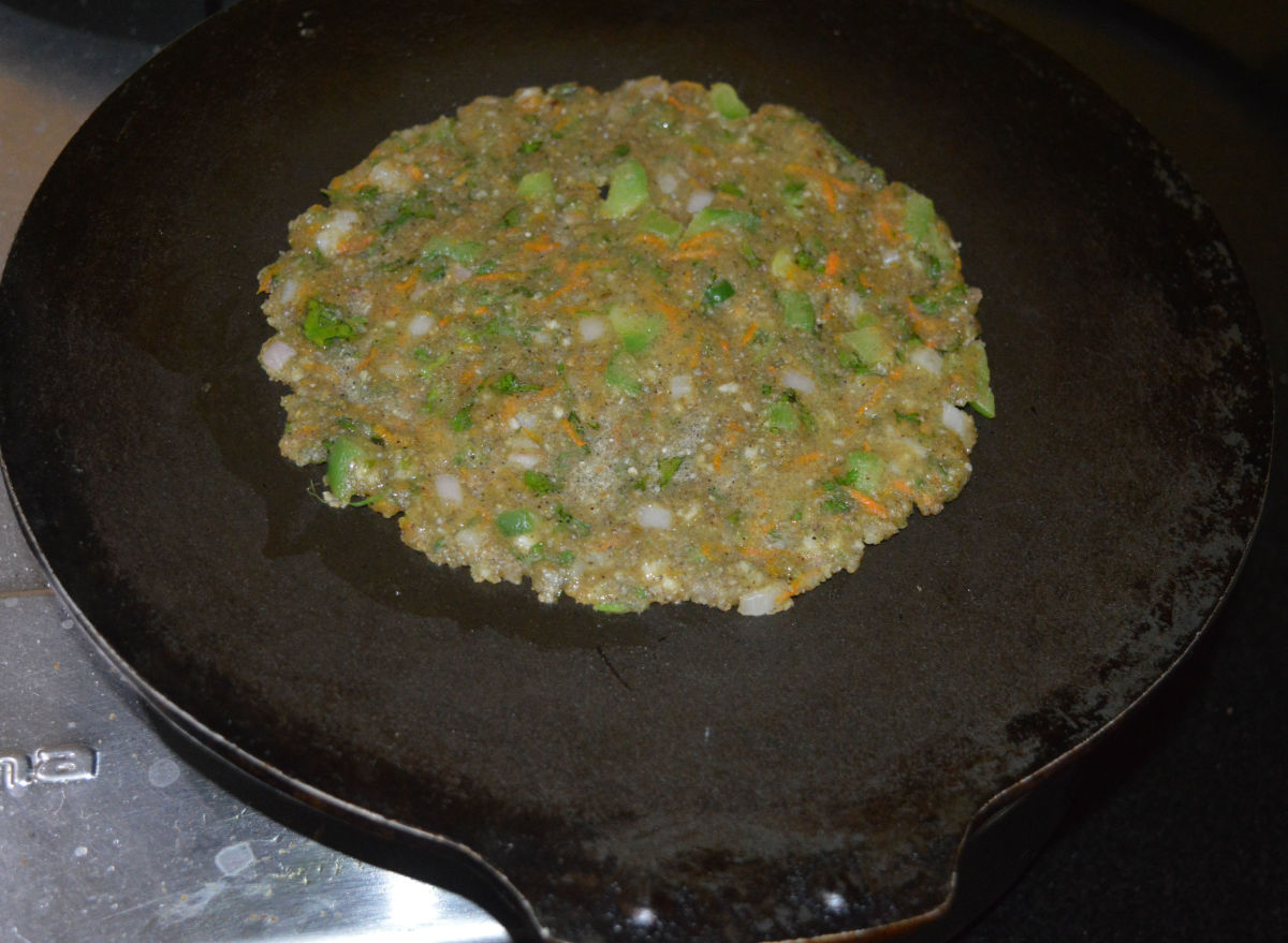 Add some oil on the top. To hasten the cooking process, cover the pan. Cook on medium heat.