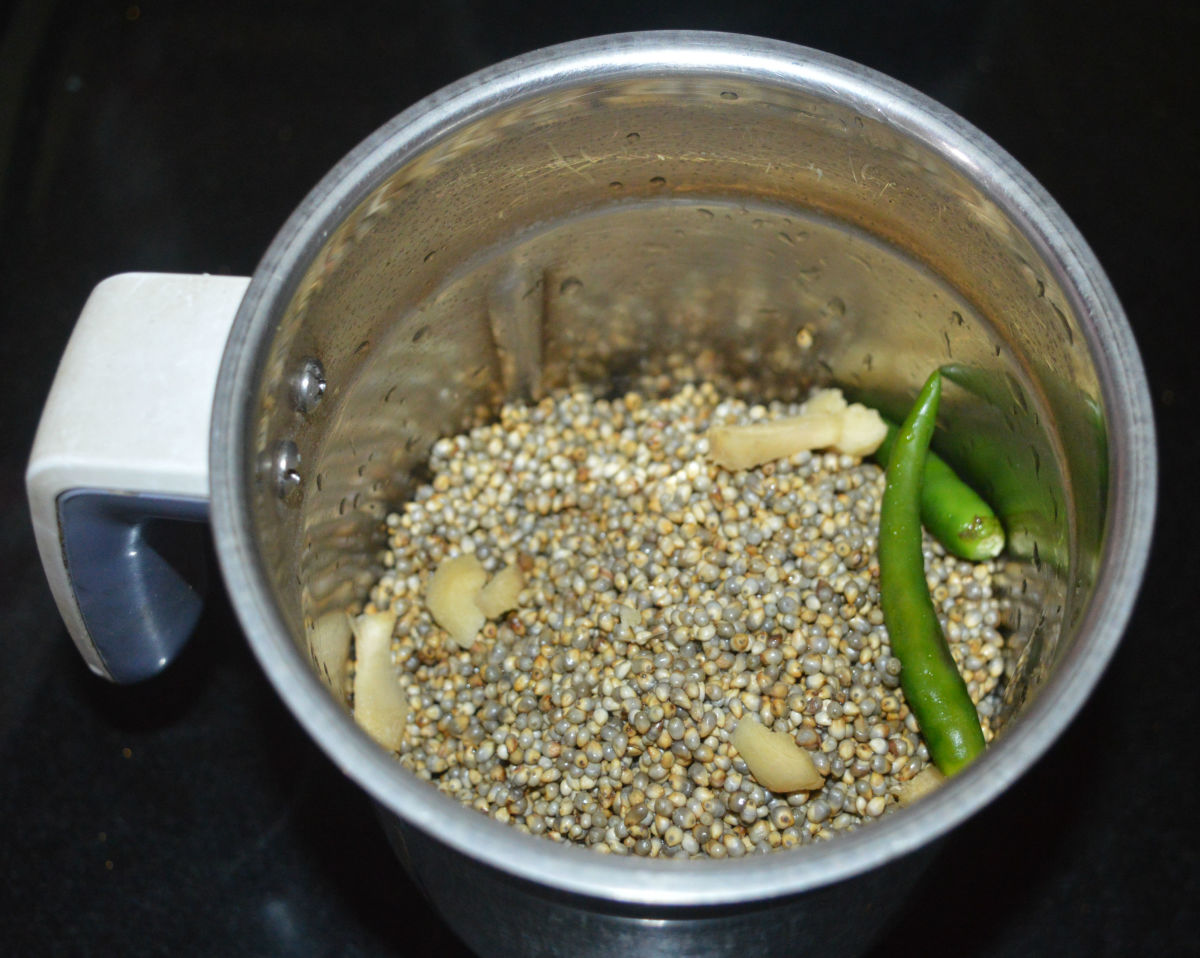 Step two: Add soaked bajra, green chilies, and ginger to a mixer jar. Grind, adding a small amount of water, to get a smooth and thick batter.