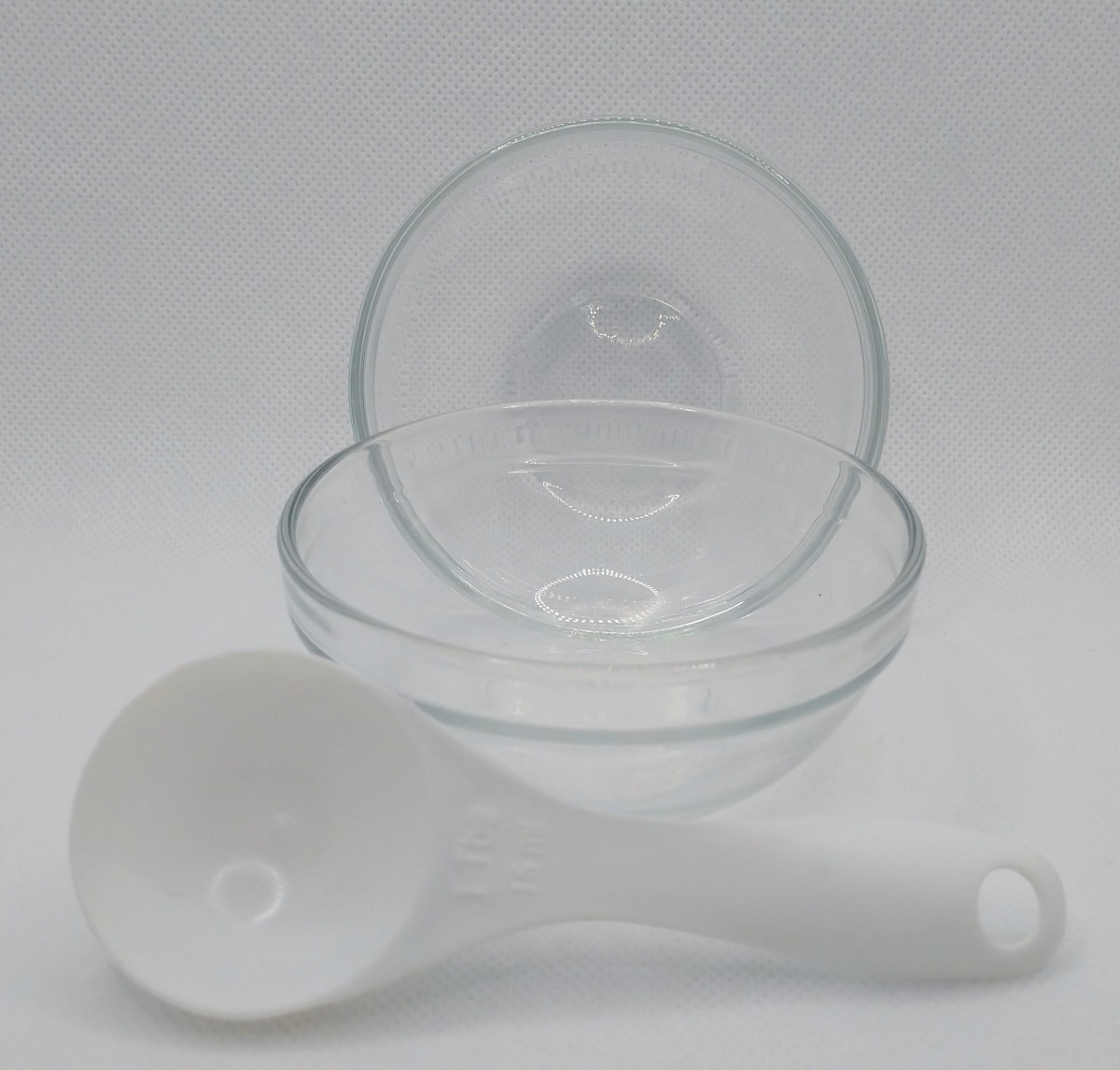 Two small glass bowls and a tablespoon measuring spoon