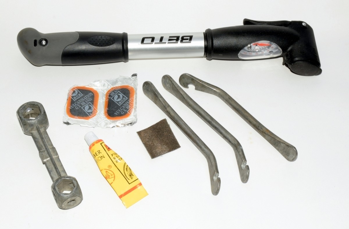 Puncture Repair Tools. A pump, multiwrench for different sized nuts, patches, glue, emery paper and tire levers.