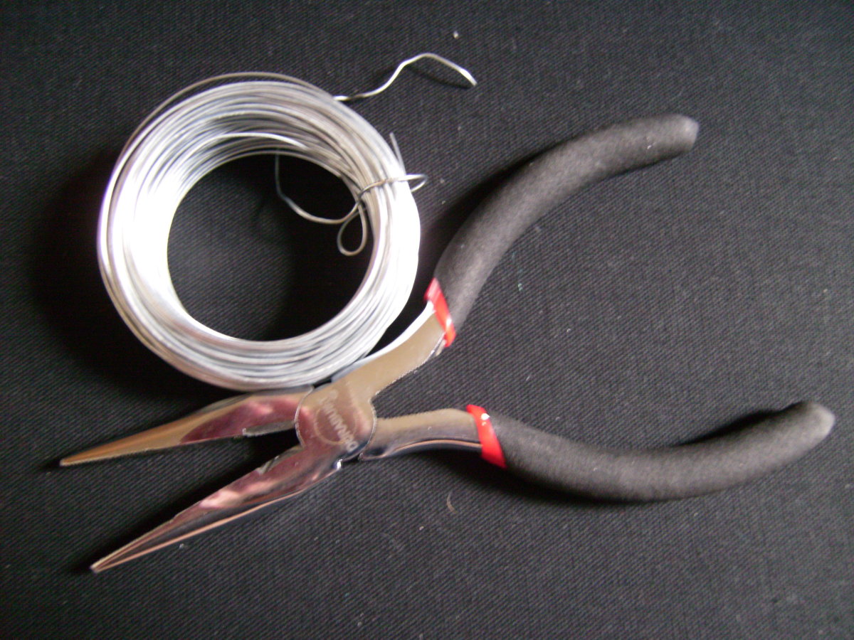 A roll of wire and needle nose pliers from a hardware store
