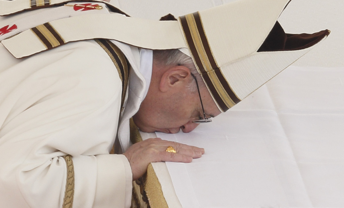 Pope Francis kissing the altar wearing the mitre looking similar to Dagon.
