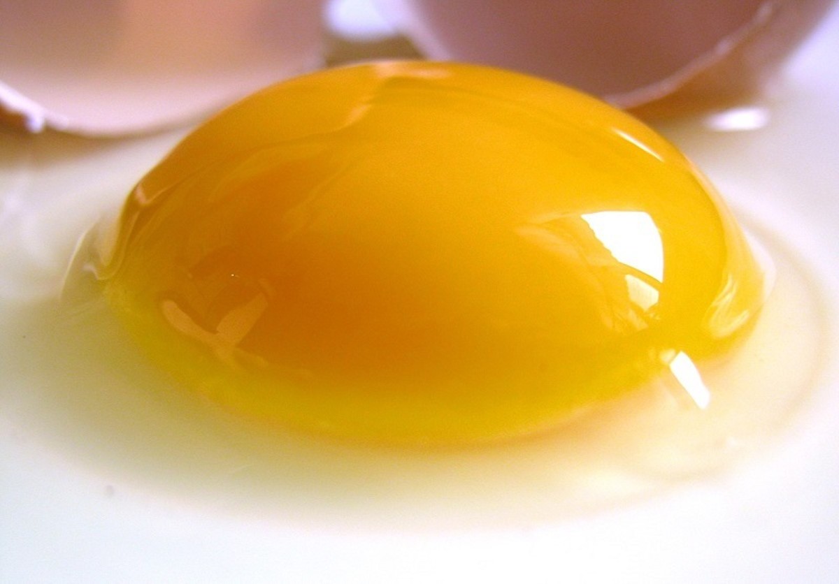 A raw hen's egg with the yolk sitting proud of the white, indicating freshness.