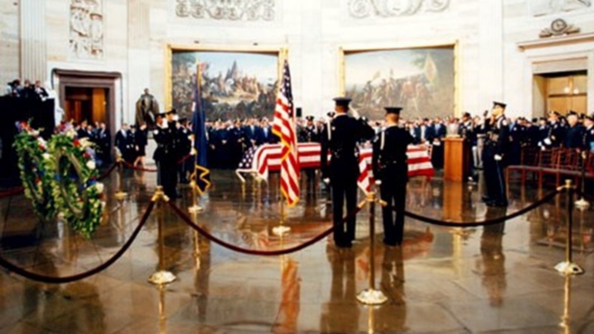 A Capitol Police Honor Guard salutes the coffins of Officer Jacob Chestnut and Detective John Gibson in the Capitol Rotunda as they lie in repose.