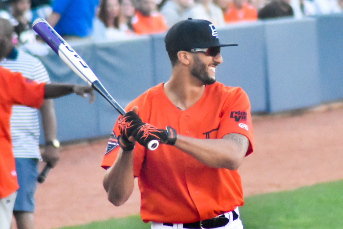 Colin Kaepernick plays in a charity softball game in 2015. He was drafted by the Chicago Cubs and also took the San Francisco 49ers to the Super Bowl.