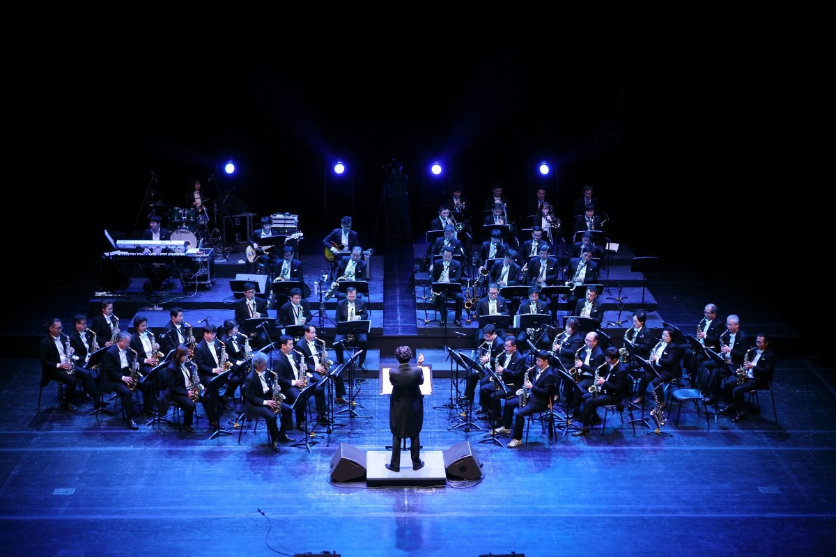 An orchestra playing in an evening performance before the public. 