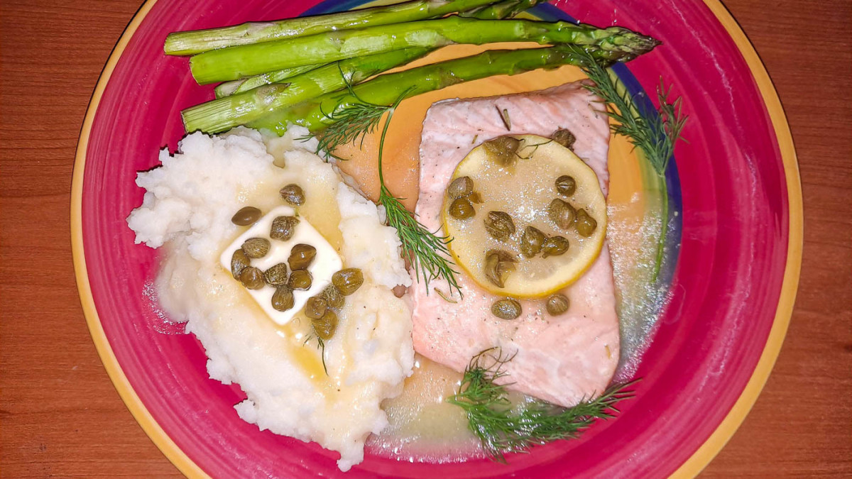 Oven-baked salmon with herbs, capers, and lemon, white wine, and pepper gravy