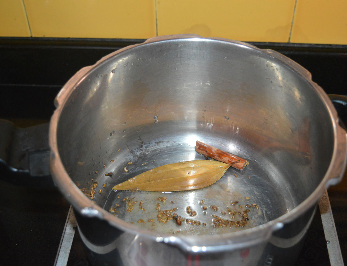 Step one: Add ghee or oil, cumin seeds, bay leaf, cloves, cinnamon stick, and cardamom to a pressure cooker. Heat it. Saute the mixture over medium heat until the cumin crackles.  