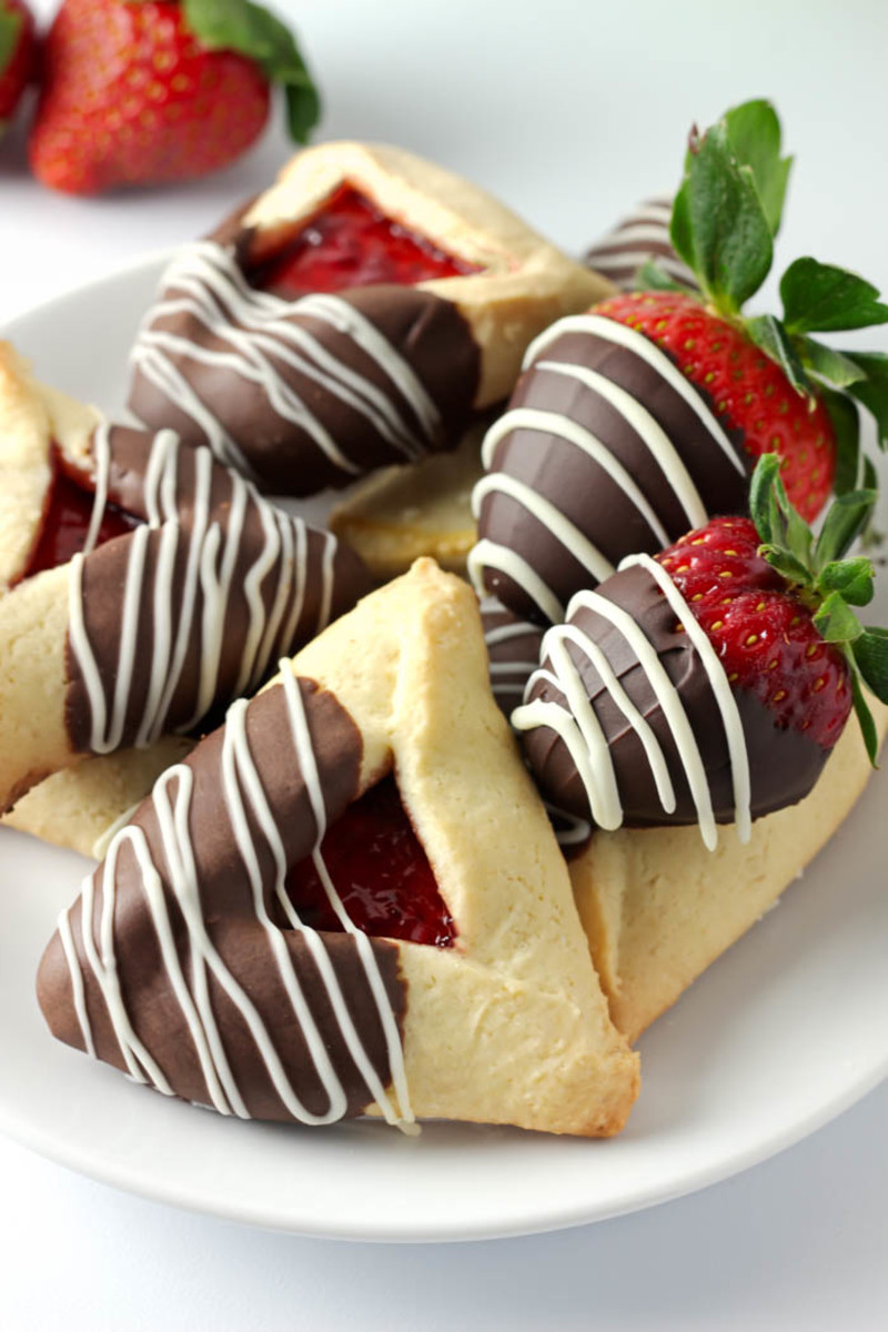 Decorated hamantaschen served with chocolate dipped strawberries