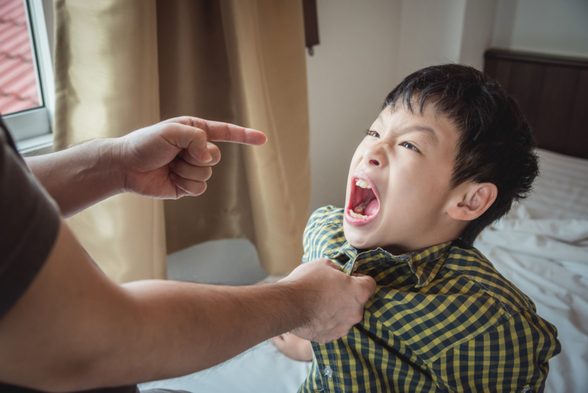 Young aggressive boy yell to his father after punishment